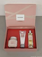 Open gift box showing three Ambre Vanille products nestled in red insert