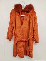 Front view of the orange Max Mara belted coat showing fur-trimmed hood and belt