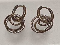 Front view of both earrings showing interlocking design and pavé stones