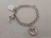 Full view of bracelet showing chain, two charms and maker tag