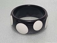 overall view of black bangle showing white polka dots