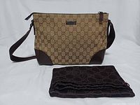 Front view of Gucci GG monogram crossbody bag with dust bag displayed