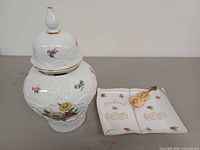 Ginger jar beside book-shaped candy dish with violin
