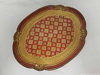 Top view of ornate oval red and gold tray