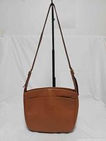 Full view of bag hanging to show overall shape and strap length