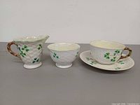 Front view of creamer, sugar bowl, teacup with saucer