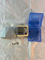 Monitor with cuff beside open blue case
