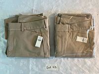 Two folded khaki pants piles, one sealed, lot overview