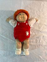 Full-length front view of doll lying flat showing outfit, shoes and hair