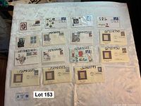 Overview of sixteen Postal Commemorative Society gold replica first-day covers laid out on table