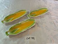 Three ceramic corn-shaped serving dishes on table