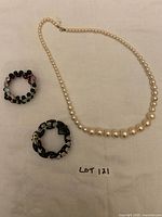 Necklace and two bracelets laid out on cloth