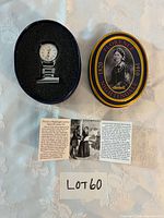Watch in foam insert next to collector tin and leaflet