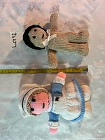 Top view of both dolls with tape measure showing length