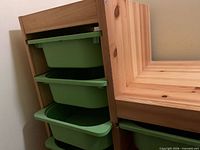 Side view of frame showing three green shallow bins in tall column