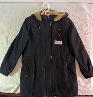 Front view of black hooded coat on hanger