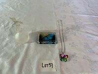 All three items: perfume bottle, butterfly paperweight, butterfly necklace