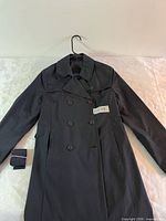 Front view of trench coat showing double-breasted design and belt