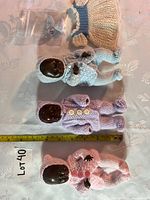 Four dolls laid out with ruler and charm bag