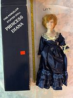 Doll beside box showing overall size next to ruler