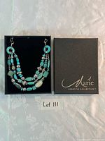 Boxed necklace showing brand logo and full view of necklace