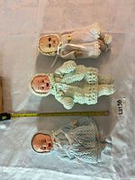 All three vintage baby dolls with knitted outfits laid out