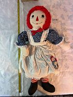 Full view of Raggedy Ann doll beside measuring tape