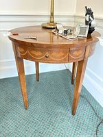 Full view of round oak veneer table with items on top