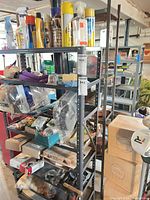 wide view of shelving with assorted tools, sprays, hardware and weights