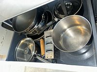 Drawer with assorted pots, pans, steamer insert, glass-lid saucepan, box grater