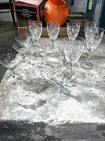Group of crystal wine goblets, cocktail coupes and nut dishes on table