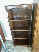 Front view of dark brown veneer bookcase with four shelves