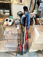 Overall view of clubs, shoes, headcovers and tool on stand