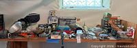 Workbench with assorted hardware, clamp light, vise, boxed supplies