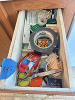 Drawer with tapes, adhesive items, toothpicks, pocket tool