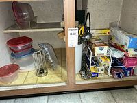 Cabinet view showing utensil crock, wire rack, boxes of wraps and bags