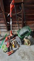 Lot overview with trimmer, spreader, hand tools, fertilizer