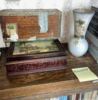 Vase, carved wooden box, and cigar box on shelf