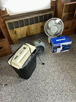 Overview of all four items: shredder in bin, Vornado heater, Lasko fan, Kobalt inflator box