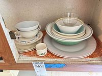 Shelf with assorted plates, bowls, toothpick holder