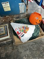 Wreath, tree skirt and jack-o-lantern bucket in cardboard tray
