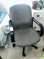 Front view of gray fabric office chair showing seat, back, armrests