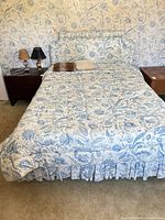 Full view of queen bed with comforter and headboard
