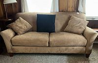 Front view of Rowe tan microfiber loveseat with three throw pillows