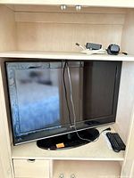 front view of Seiki TV in cabinet with accessories