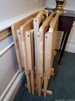 Four folded tray tables stored in stand