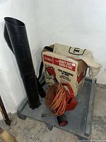 Toro 550 TBX blower-vac with extension tube, collection bag and box on dolly