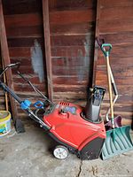 Full view of Toro snowblower with shovels beside