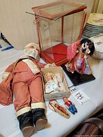 Overall lot showing Santa doll, display case parts, boxed Storybook doll, cradleboard baby, small boy doll
