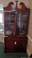 Full view of Drexel china cabinet showing glass upper doors, finial and lower storage